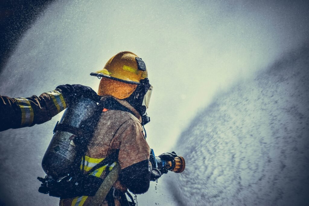 pexels photo 2030190 2030190 A brave firefighter in protective gear sprays water during training or emergency.
